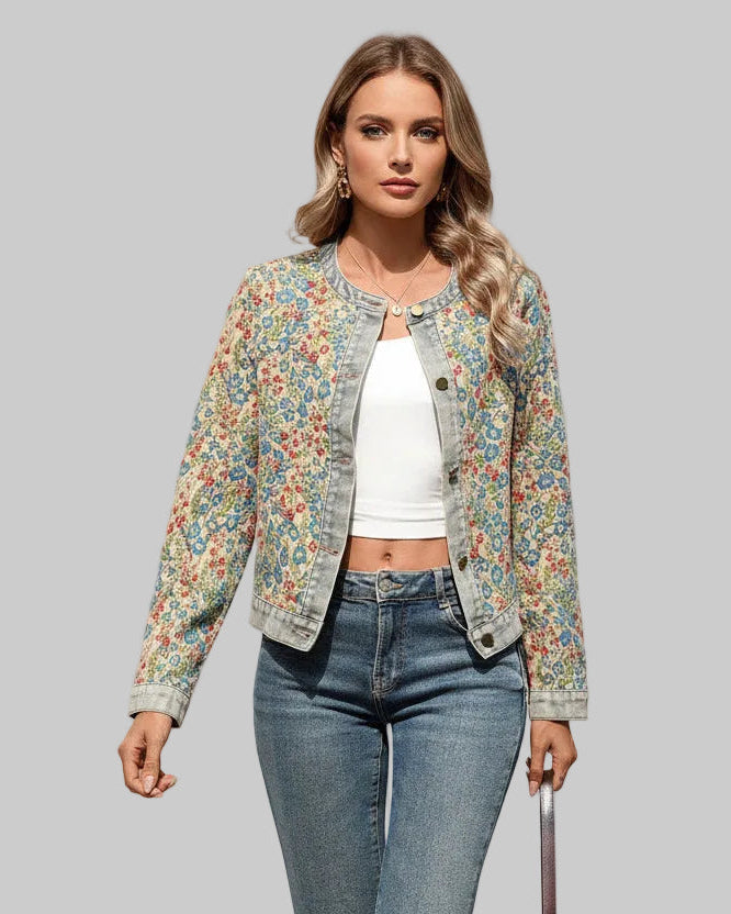 Woman wearing a floral jacket and jeans walking outdoors.