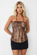 Woman wearing a leopard print top and black skirt on a white background