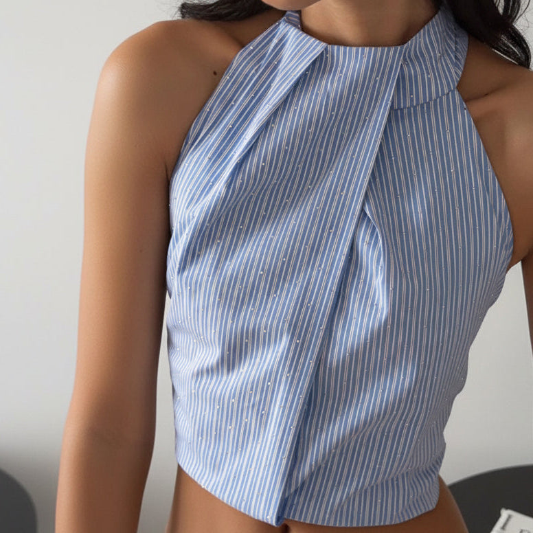 Blue and white striped halter top worn by a person against a neutral background