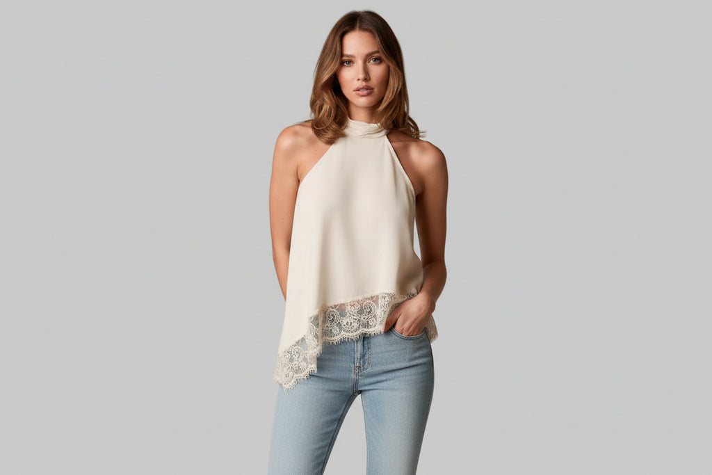 Woman wearing a white halter top with lace trim on a neutral background
