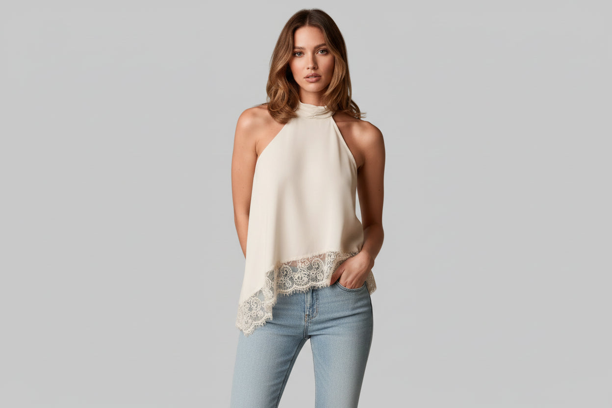 Woman wearing a white halter top with lace trim on a neutral background