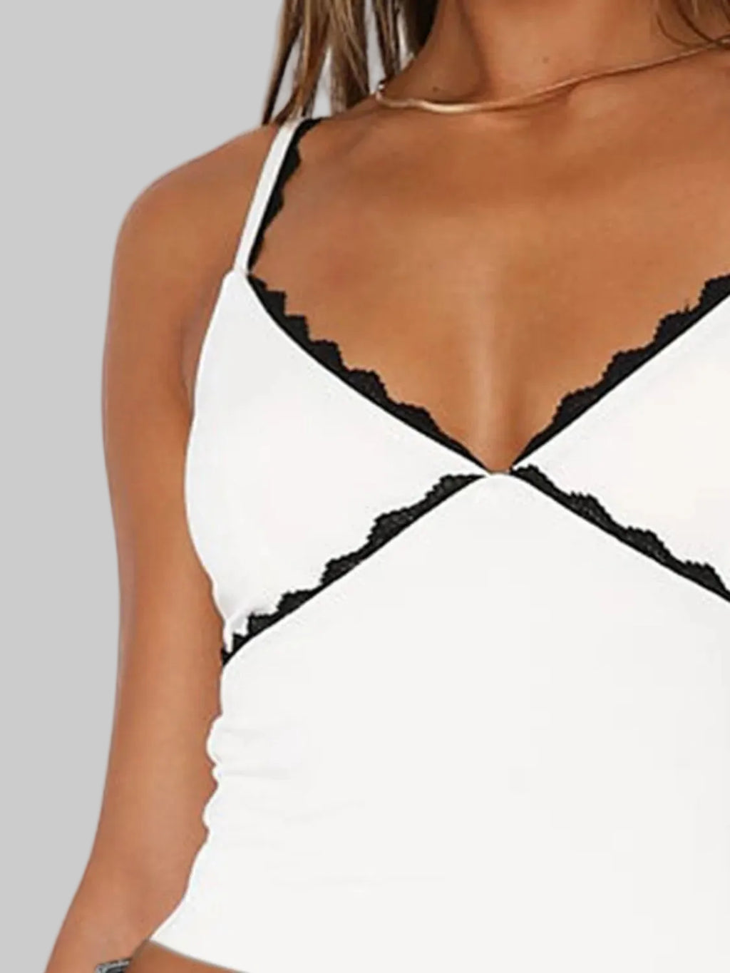 White top with black lace trim on a white background