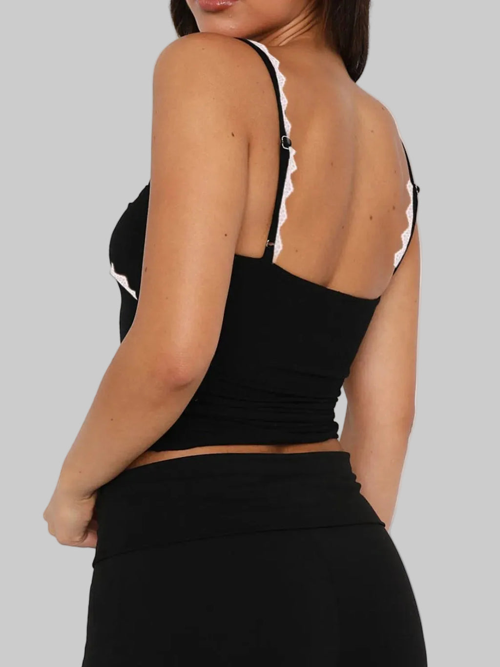 Black crop top with thin straps on a white background